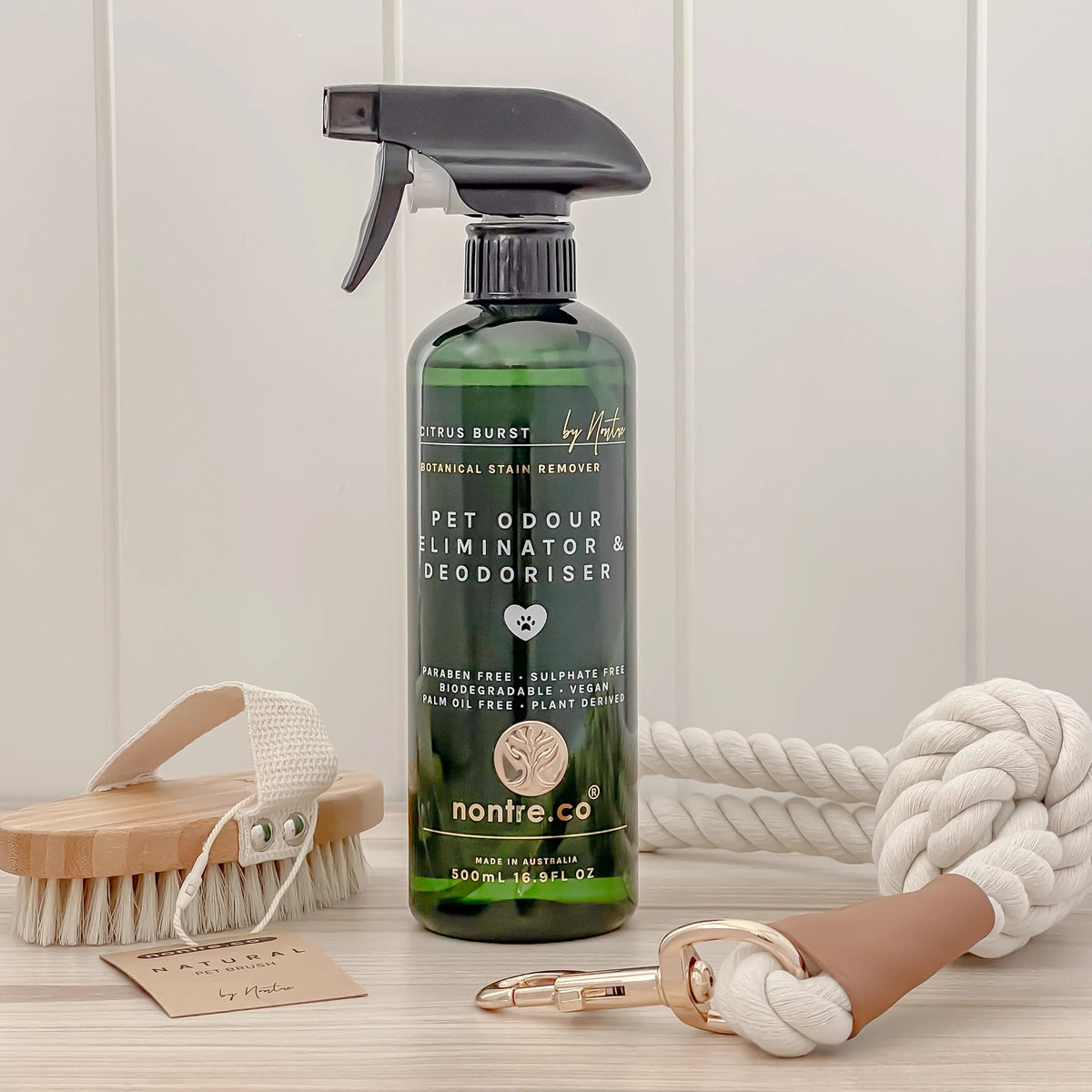 Nontre.co Pet Odour Eliminator styled with a wooden pet brush and a rope lead
