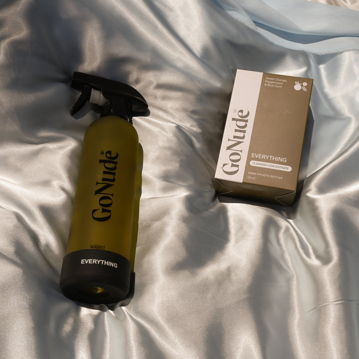 Go Nude Everything cleaning set with the Sweet Orange, Peppermint and Blue Gum concentrate carton beside its olive 400ml refillable glass spray bottle