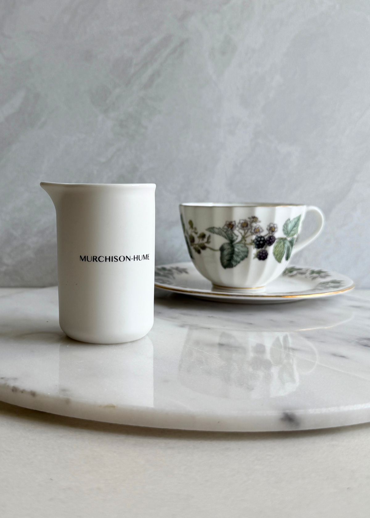 Murchison-Hume ceramic measuring cup pouring concentrate into a bottle