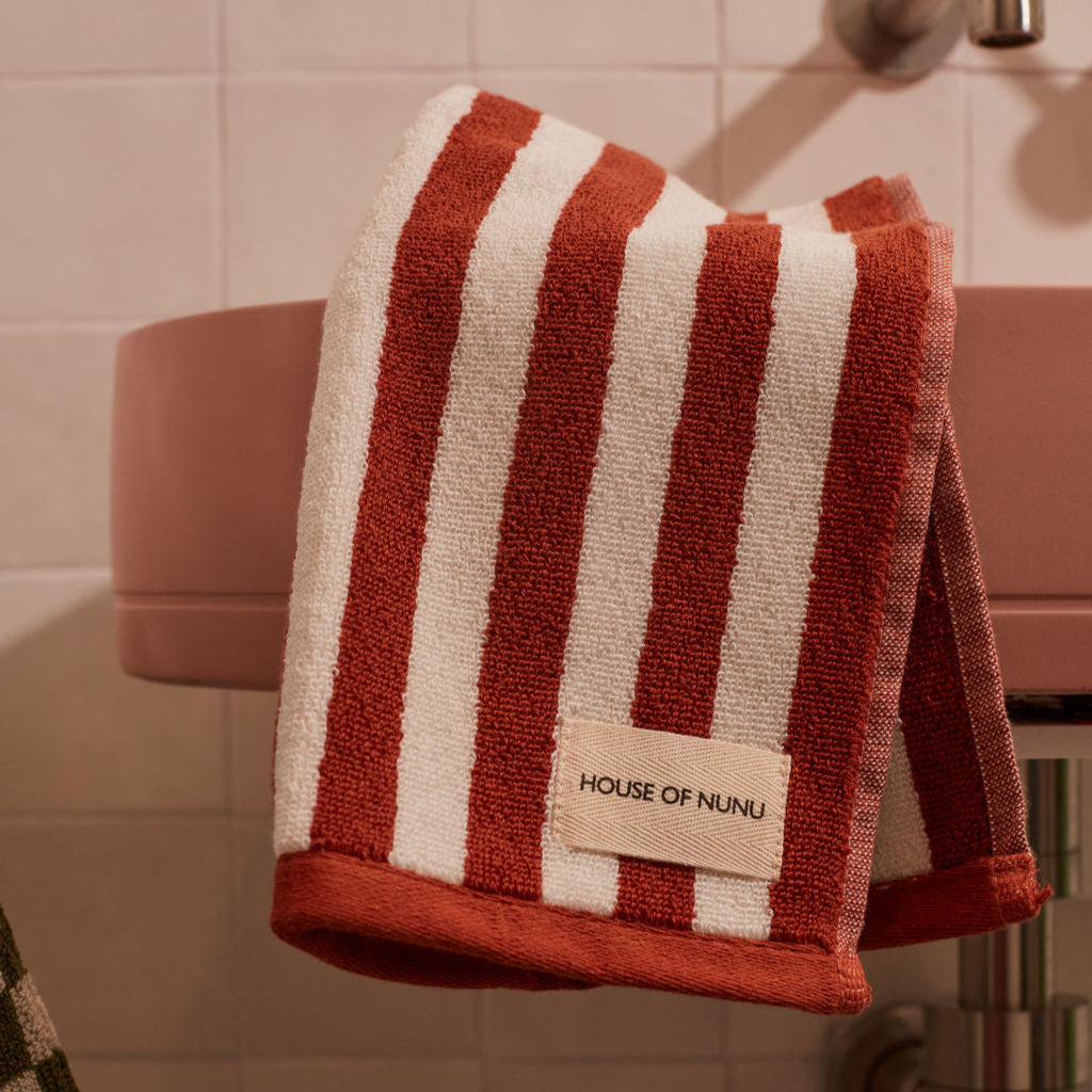 House of Nunu Red Ochre Stripe towel on a bathroom rail