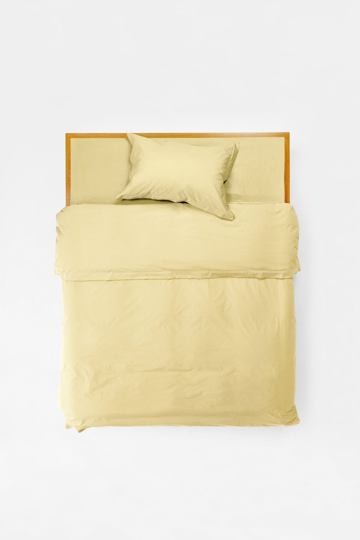Studio Sutram Maize duvet cover folded back at the top of a bed