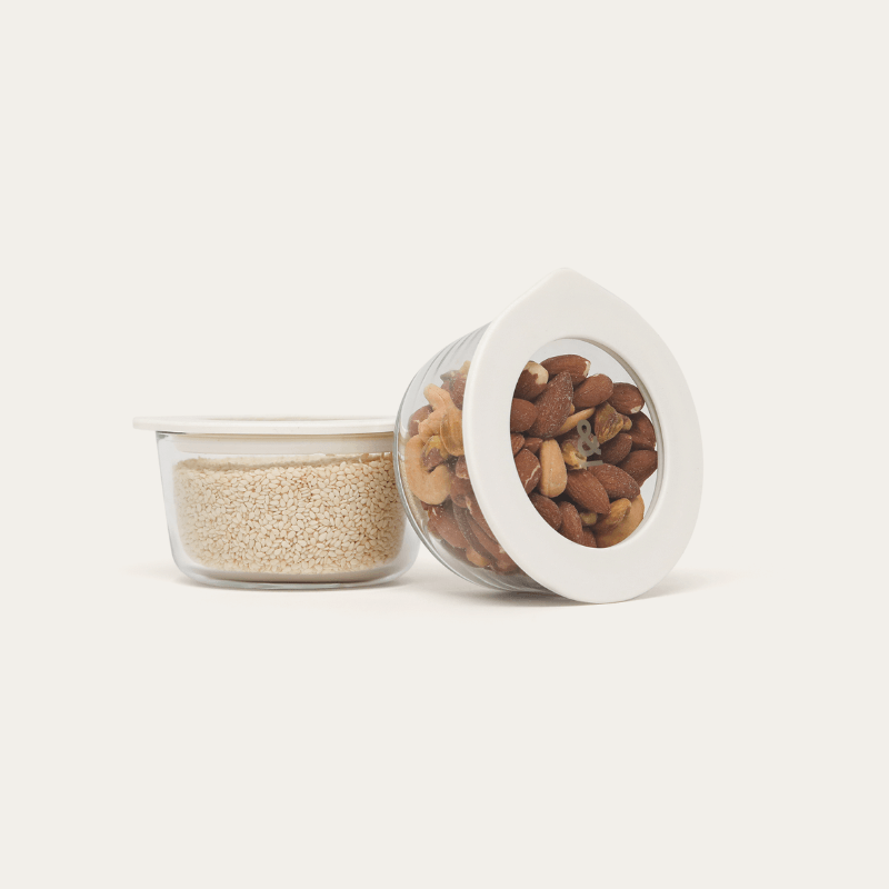 Two Oat Milk glass dip bowls, one with its glass lid leaning against it