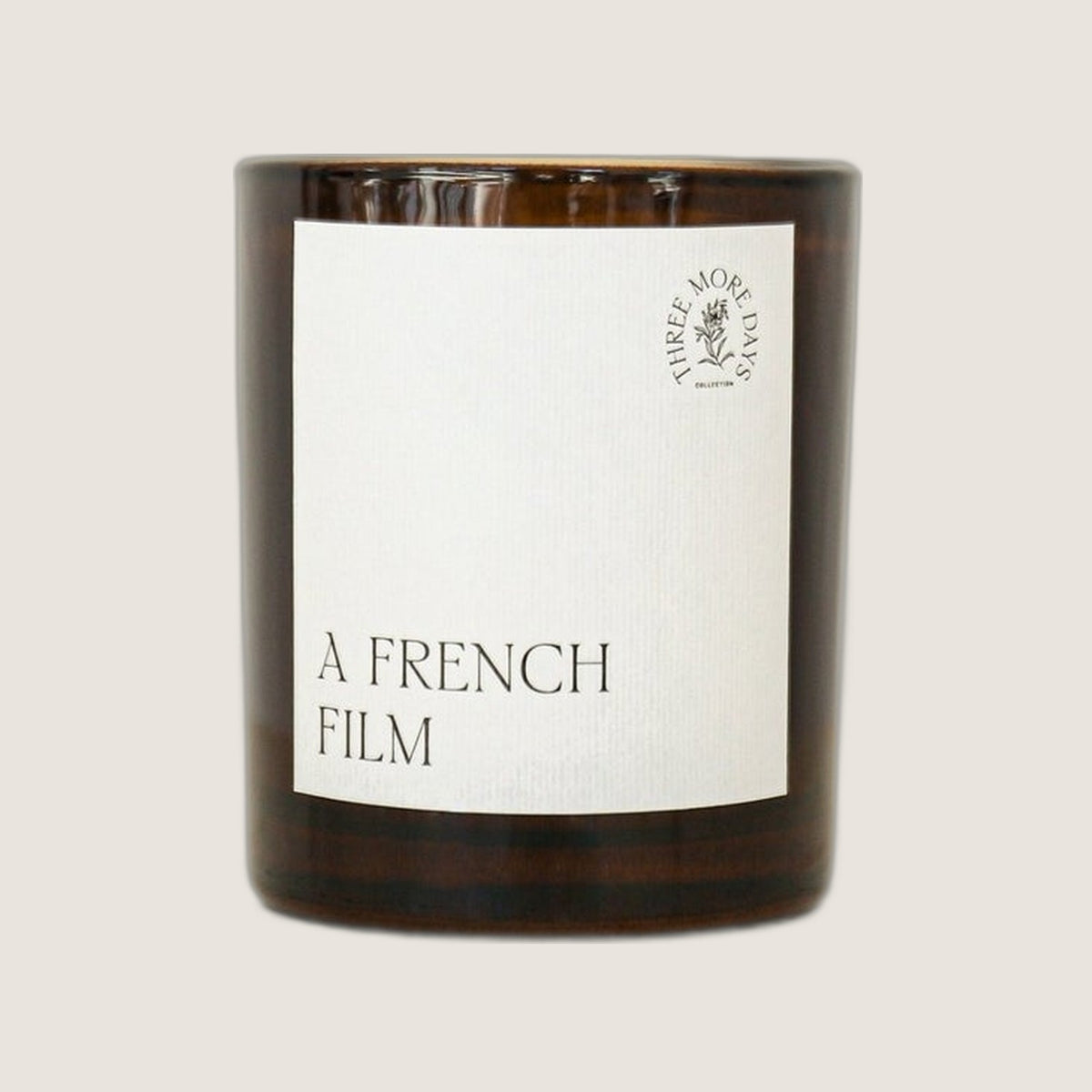 Three More Days A French Film candle in an amber glass jar with a white label