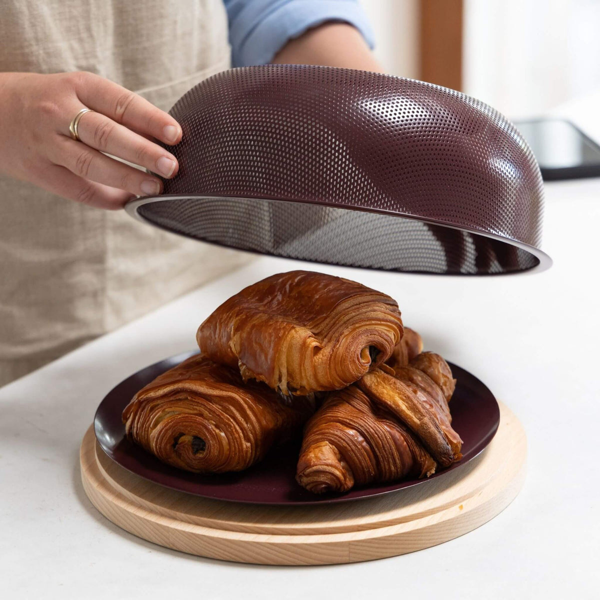 Lifting the Mulberry steel lid to reveal pastries on the beechwood board beneath