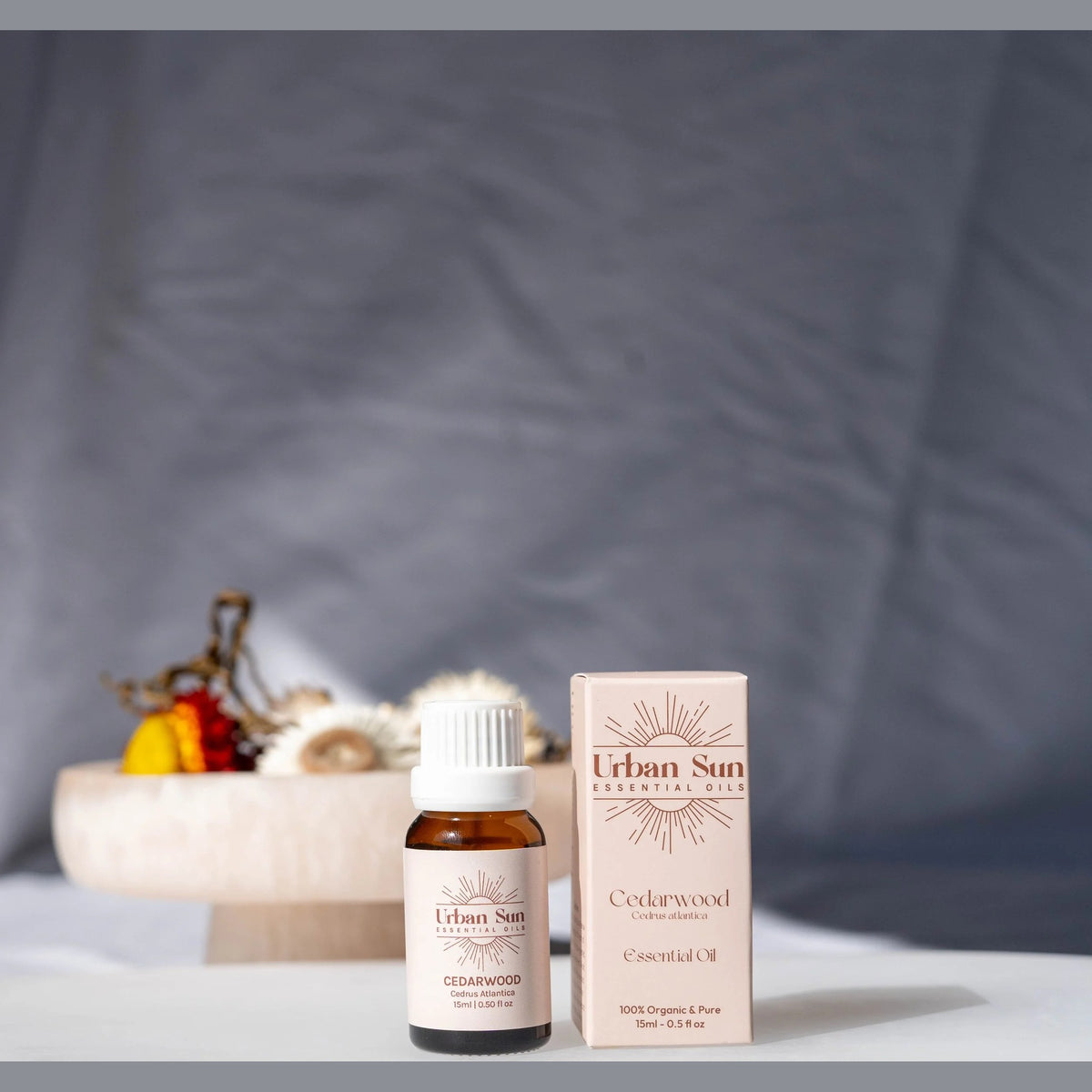 Urban Sun Cedarwood essential oil bottle beside its printed carton