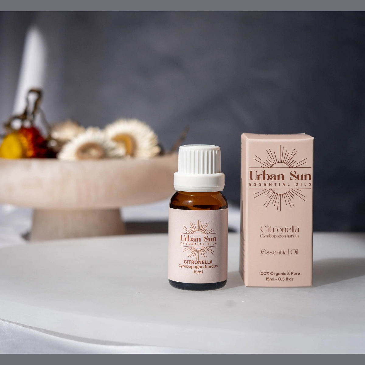 Urban Sun Citronella essential oil bottle beside its printed carton