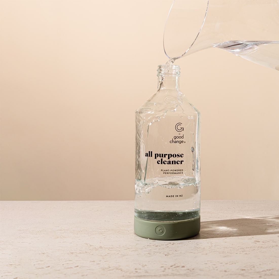 Filling the Good Change glass bottle with water to dissolve a cleaning tablet