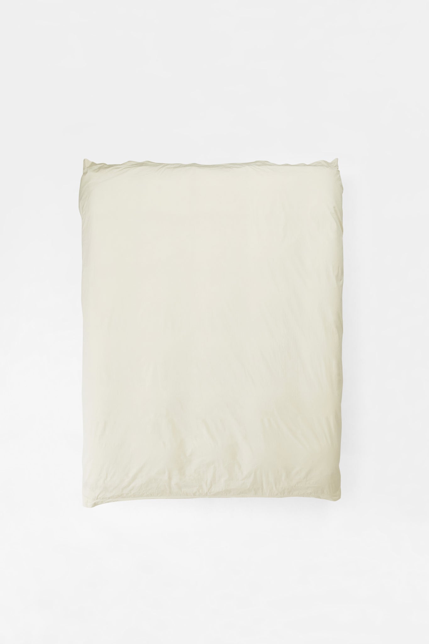 A bed made up in warm off-white organic cotton percale, the highest contact-time product in the house