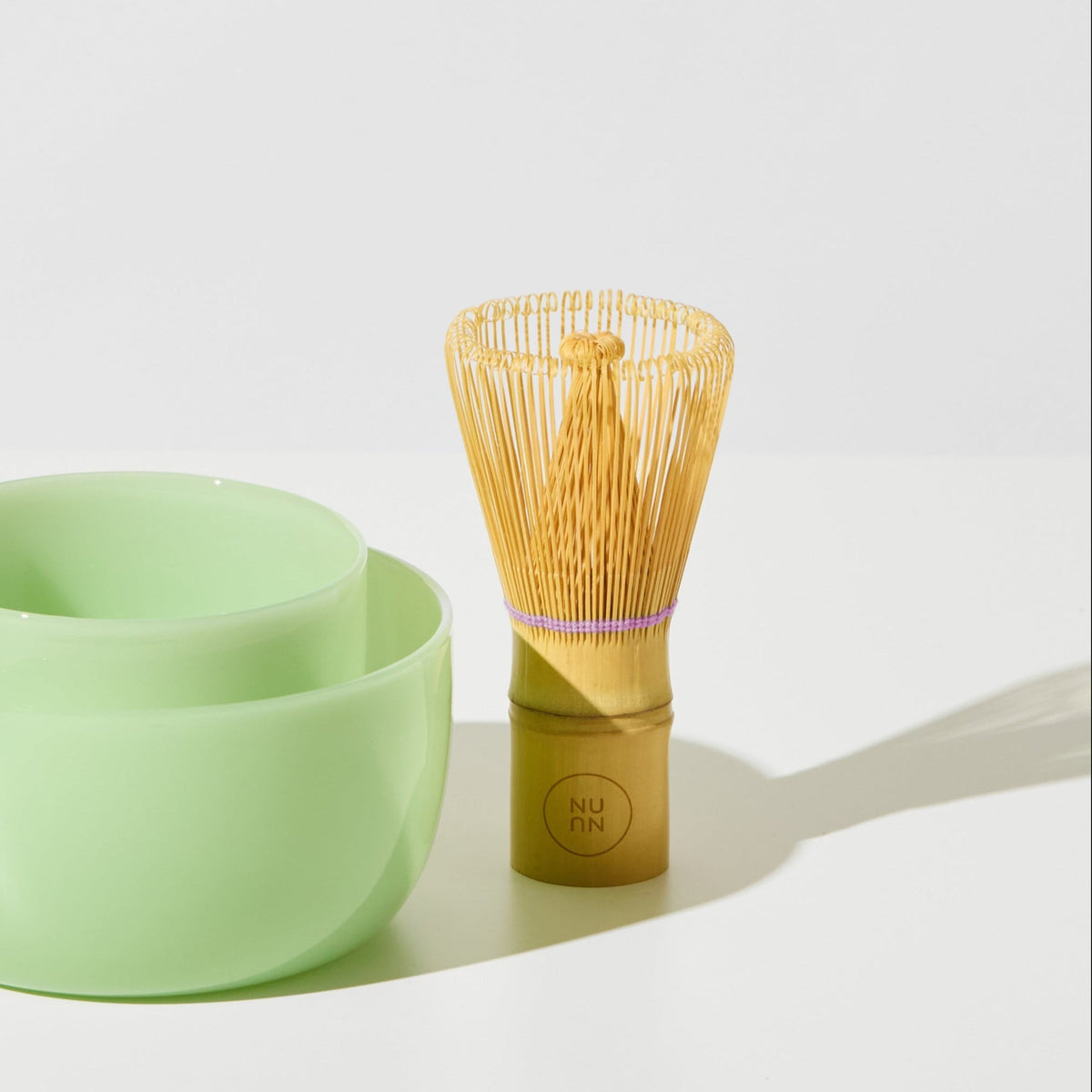House of Nunu Matchy Matcha bamboo whisk beside the pistachio glass bowl