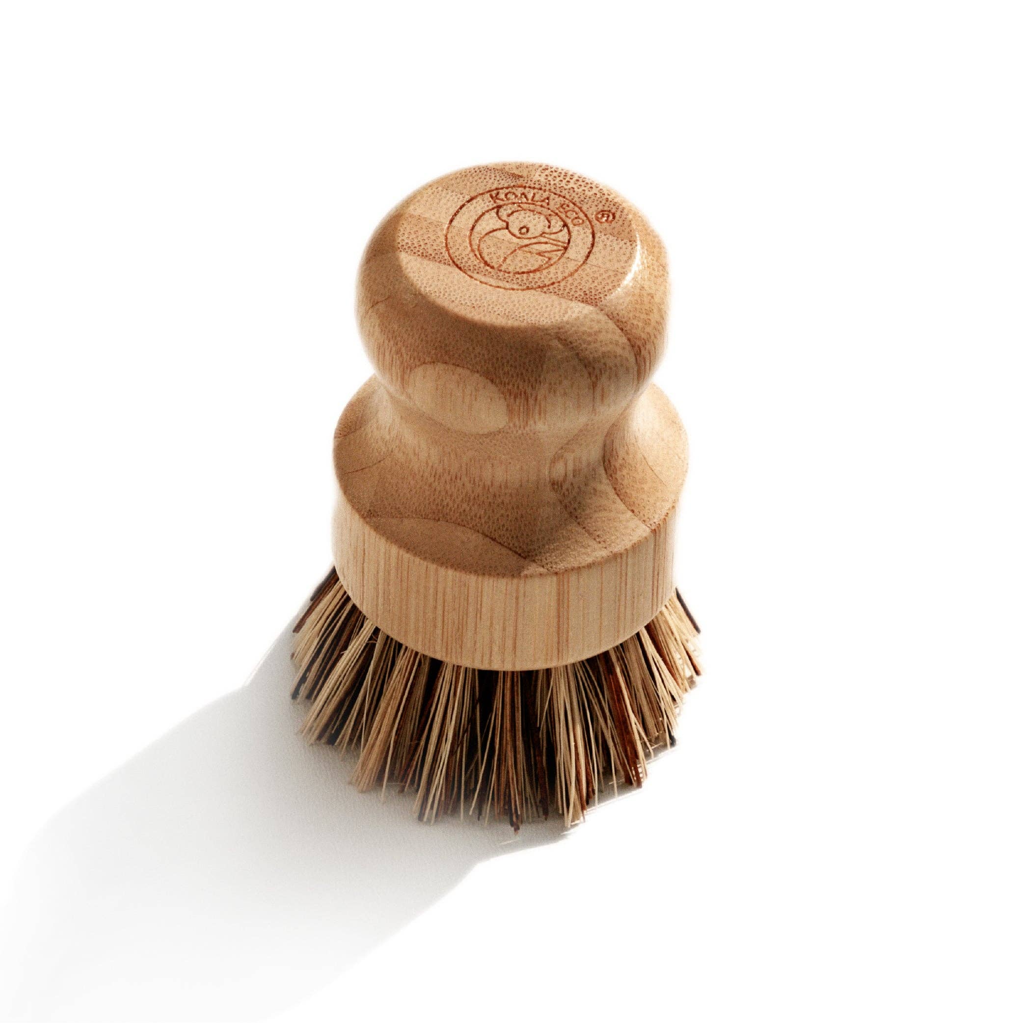 Koala Eco bamboo scrubbing brush from above, showing the stamped logo on the circular palm-sized base and agave bristles