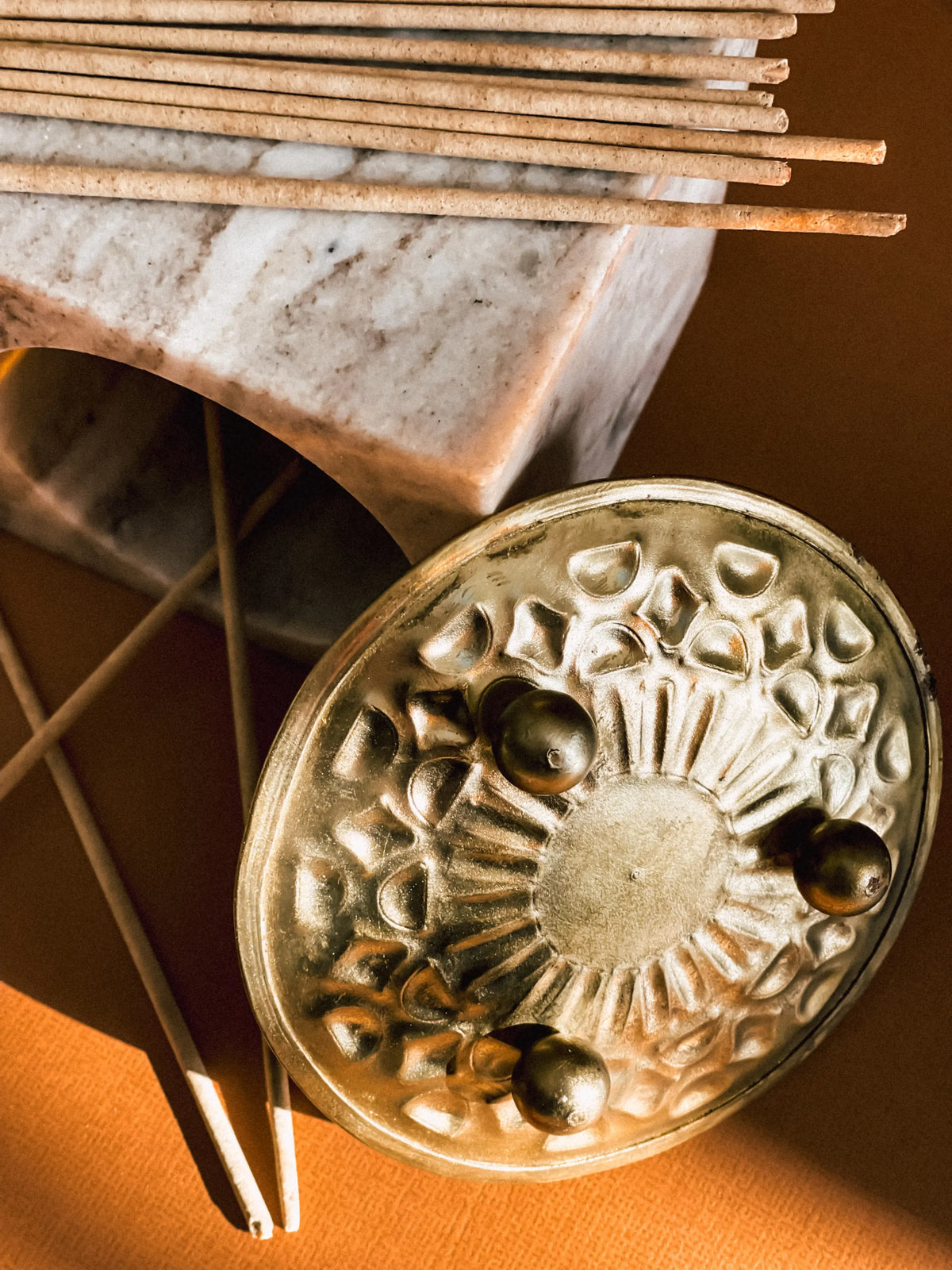 Urganiqa incense sticks on marble with a brass incense holder
