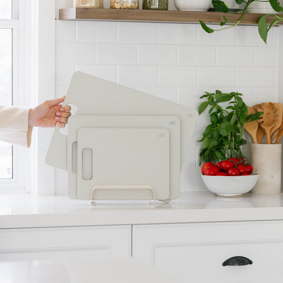 A hand lifting a Mushroom cellulose board from a kitchen bench, showing how slim it is