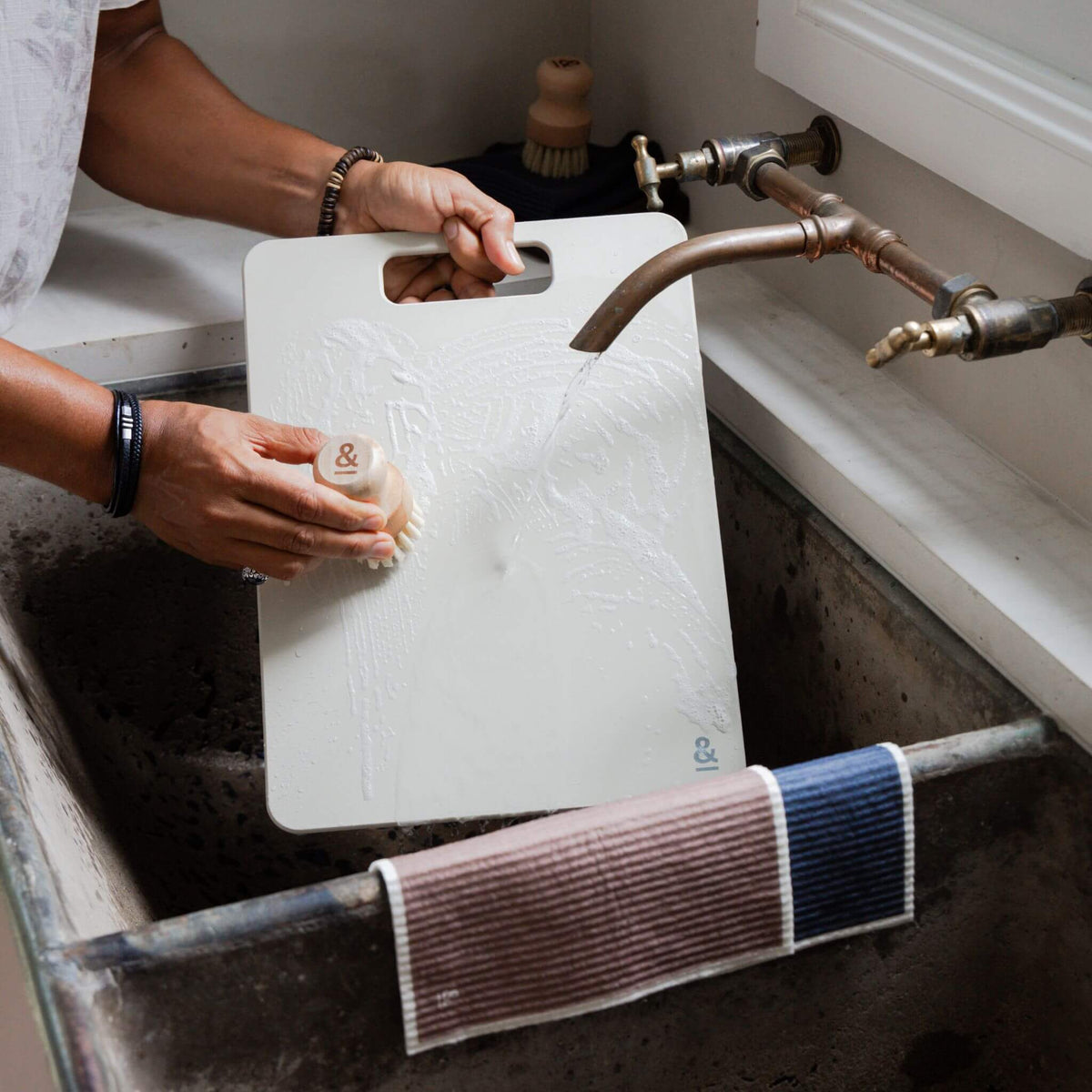 Rinsing a Mushroom cellulose chopping board under the tap