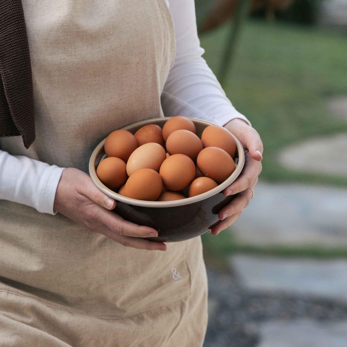 A Macadamia enamel bowl held full of fresh brown eggs