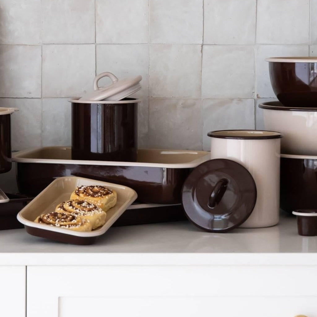 Both Macadamia enamel storage jars on a tiled kitchen bench with enamel trays
