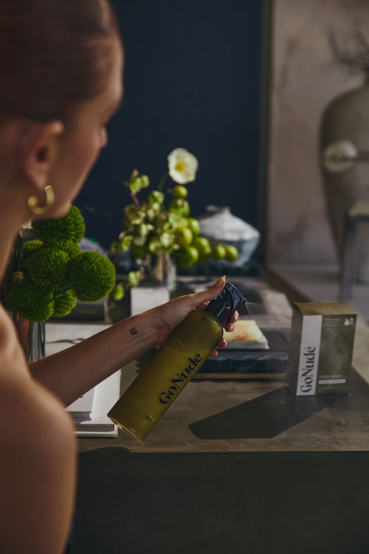 Go Nude olive Keeper spray bottle in use