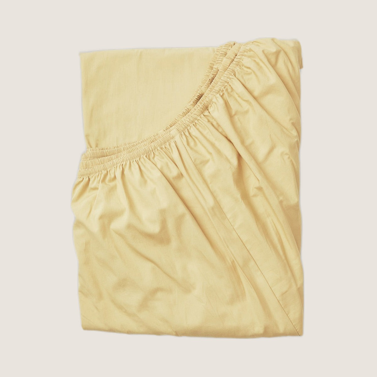 Studio Sutram Maize fitted sheet in soft yellow organic cotton percale, folded
