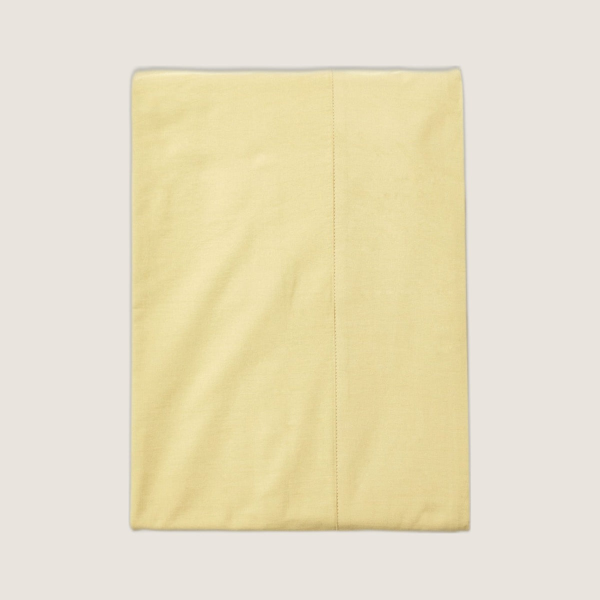 Studio Sutram Maize flat sheet folded on greige