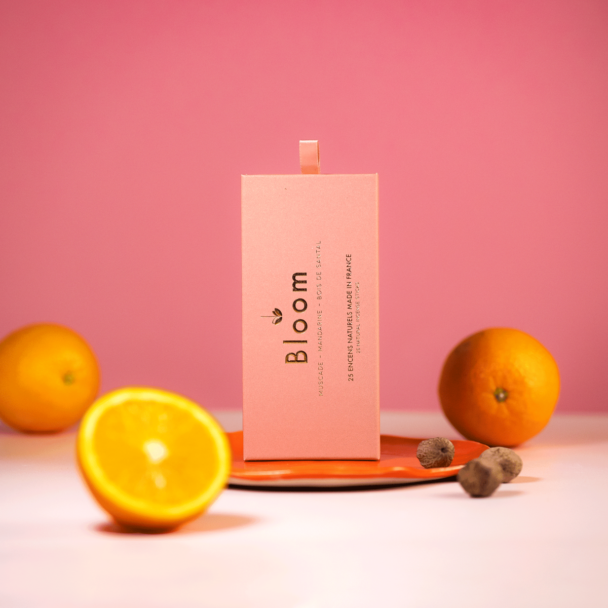Bloom France Mandarine incense box styled with whole oranges and nutmeg on a coral dish