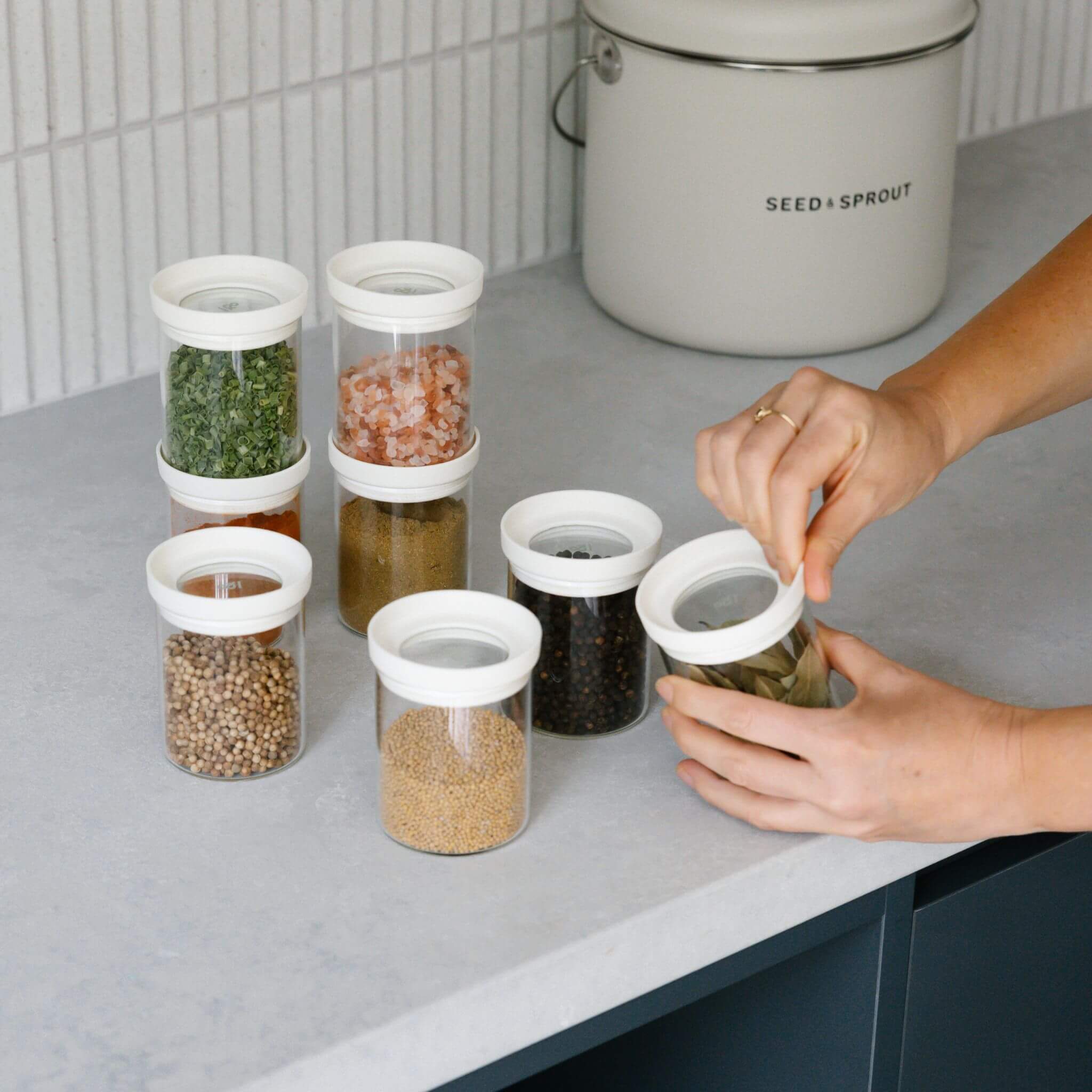 Seed & Sprout glass spice jars being filled on a bench